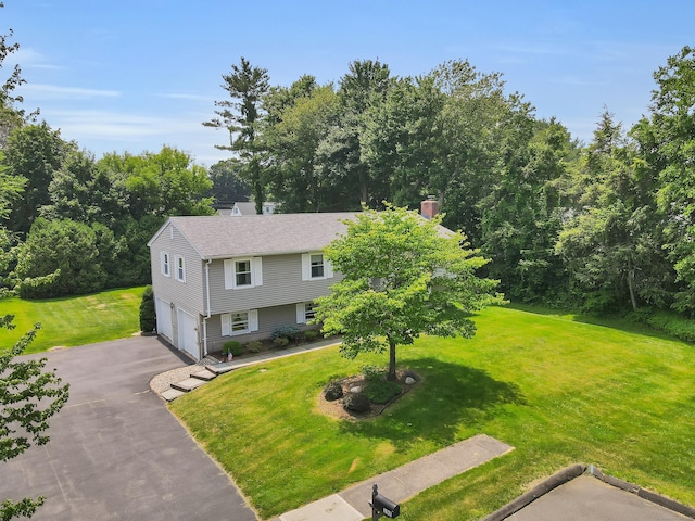 197 Hummingbird Dr, Berlin, CT 06037 - view of front of house with asphalt driveway, an attached garage, a chimney, and a front yard