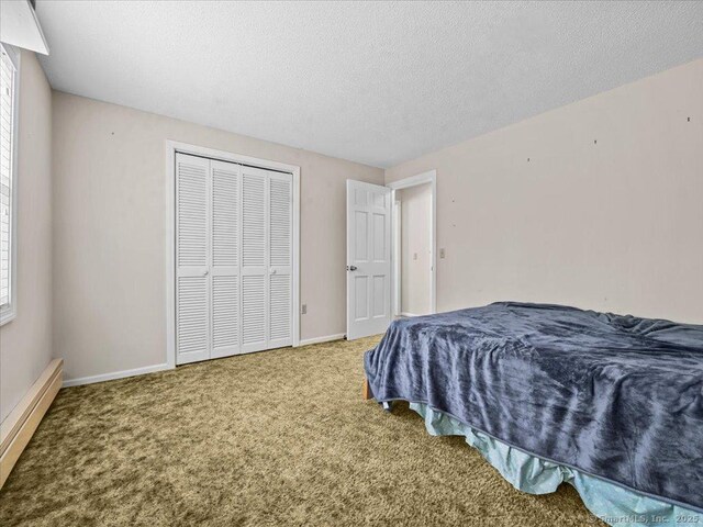 5 Marian Ln, Clinton, CT 06413 - bedroom featuring a baseboard radiator, carpet, a closet, baseboards, and a textured ceiling