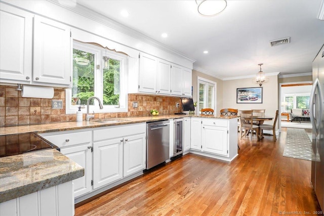 10 Hundred Acres Rd, Newtown, CT 06470 - kitchen with stainless steel dishwasher, a sink, a peninsula, light wood-type flooring, and white cabinetry