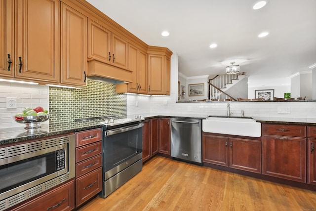 177 S Ave Unit 6, New Canaan, CT 06840 - kitchen with appliances with stainless steel finishes, a sink, custom range hood, dark stone countertops, and crown molding