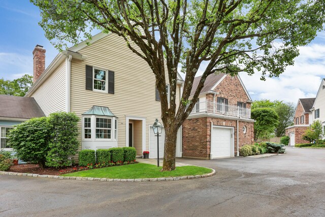 177 S Ave Unit 6, New Canaan, CT 06840 - view of front of home with asphalt driveway, a garage, brick siding, and a chimney