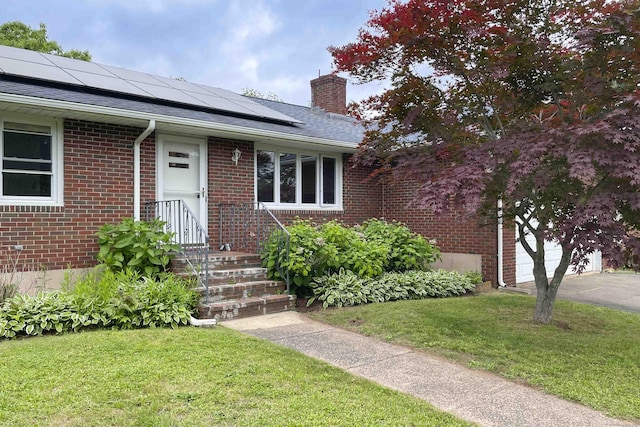 92 Milardo Ln, Middletown, CT 06457 - view of front of house with a front lawn, solar panels, a chimney, and brick siding