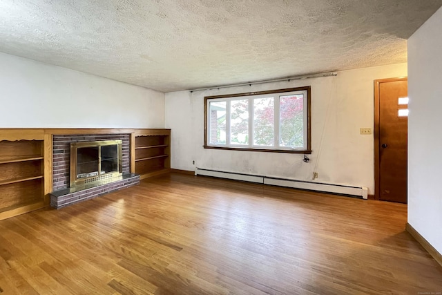 92 Milardo Ln, Middletown, CT 06457 - unfurnished living room with a textured ceiling, wood finished floors, baseboard heating, a brick fireplace, and baseboards