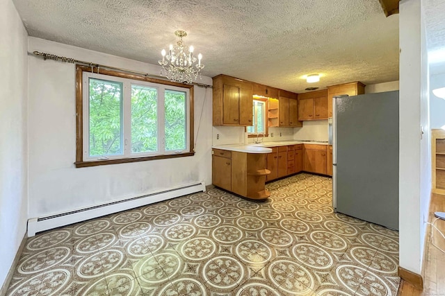 92 Milardo Ln, Middletown, CT 06457 - kitchen featuring freestanding refrigerator, baseboard heating, light countertops, a peninsula, and a chandelier