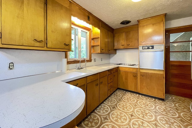92 Milardo Ln, Middletown, CT 06457 - kitchen featuring wall oven, a sink, light countertops, open shelves, and brown cabinets