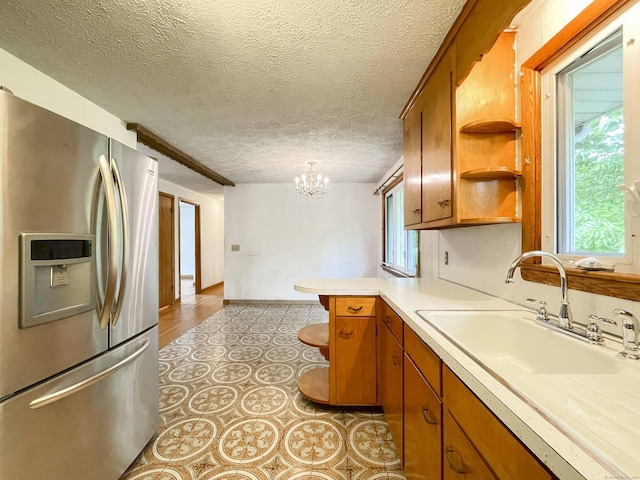 92 Milardo Ln, Middletown, CT 06457 - kitchen with stainless steel fridge, open shelves, a sink, brown cabinets, and a peninsula