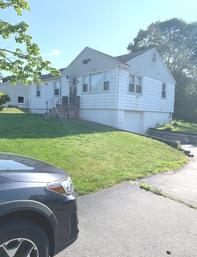 9 Hillcrest Ave, Ledyard, CT 06339 - ranch-style house with board and batten siding, a front yard, and a garage