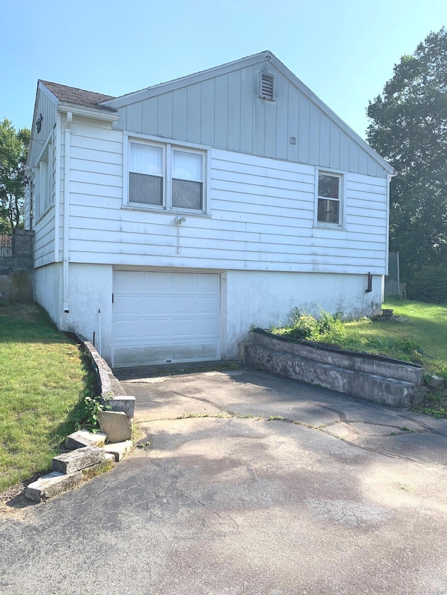 9 Hillcrest Ave, Ledyard, CT 06339 - view of home's exterior with driveway, an attached garage, a yard, and board and batten siding