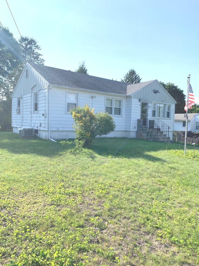 9 Hillcrest Ave, Ledyard, CT 06339 - single story home with board and batten siding, a front lawn, and cooling unit