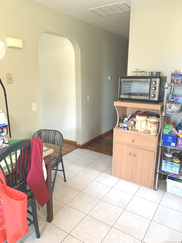 9 Hillcrest Ave, Ledyard, CT 06339 - kitchen featuring arched walkways, light tile patterned floors, light brown cabinets, and baseboards