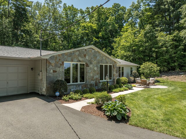 24 Sky Ridge Dr, Somers, CT 06071 - view of front facade with stone siding, a garage, a front yard, driveway, and a shingled roof