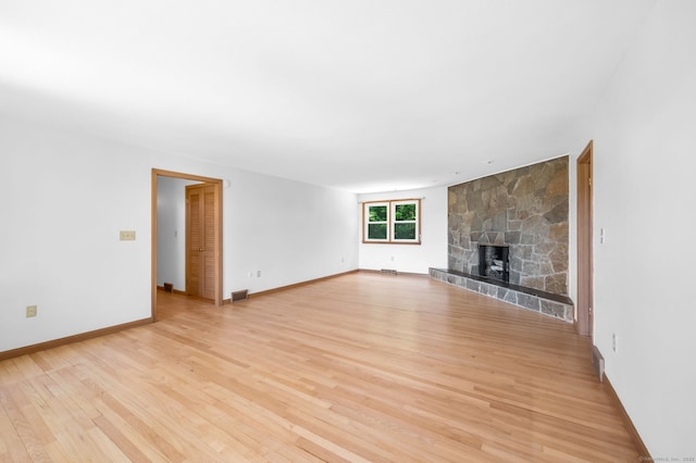 24 Sky Ridge Dr, Somers, CT 06071 - unfurnished living room with light wood finished floors, baseboards, and a stone fireplace