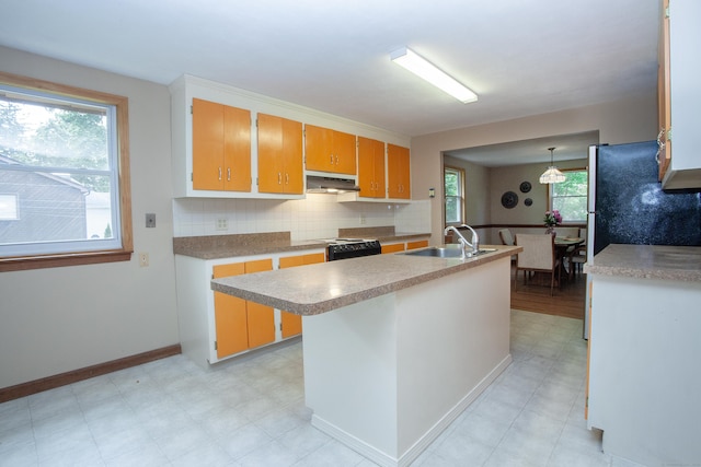 6 Cadwell St, West Hartford, CT 06107 - kitchen with light floors, under cabinet range hood, light countertops, backsplash, and a center island with sink