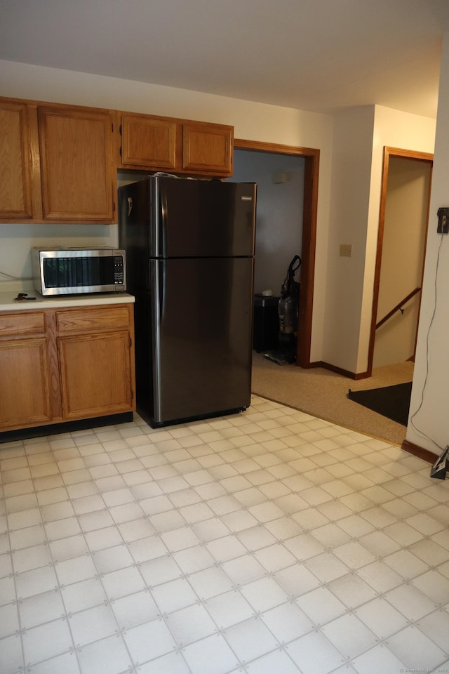 155 Jackson St, Ansonia, CT 06401 - kitchen with freestanding refrigerator, stainless steel microwave, light countertops, and brown cabinetry