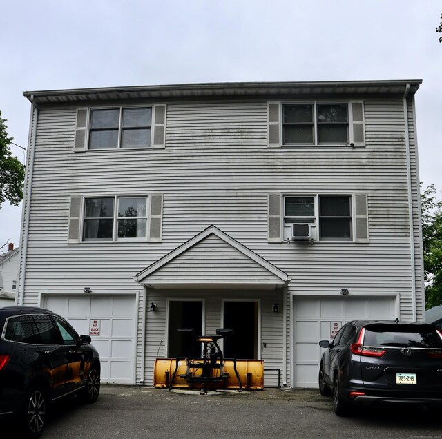 155 Jackson St, Ansonia, CT 06401 - view of property featuring an attached garage, driveway, and cooling unit