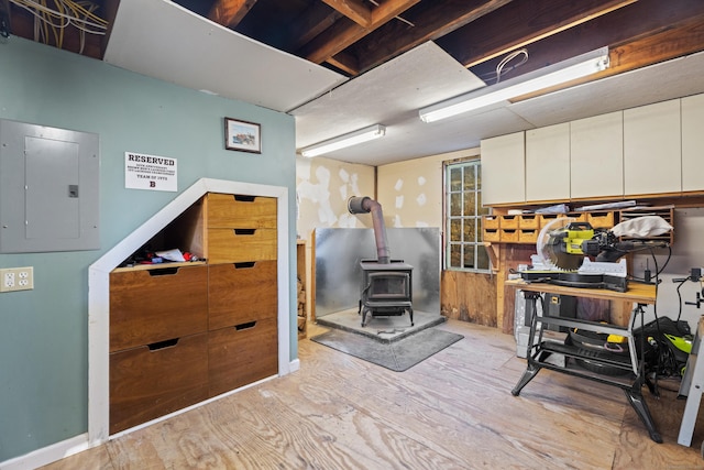 70 River Rd, East Haddam, CT 06423 - misc room with electric panel, a wood stove, and wood finished floors