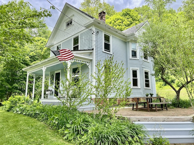70 River Rd, East Haddam, CT 06423 - view of side of home with covered porch, a chimney, and a lawn