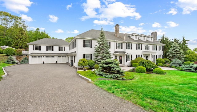 184 Fern Ave, Litchfield, CT 06759 - view of front of house featuring an attached garage, driveway, a front lawn, and a chimney