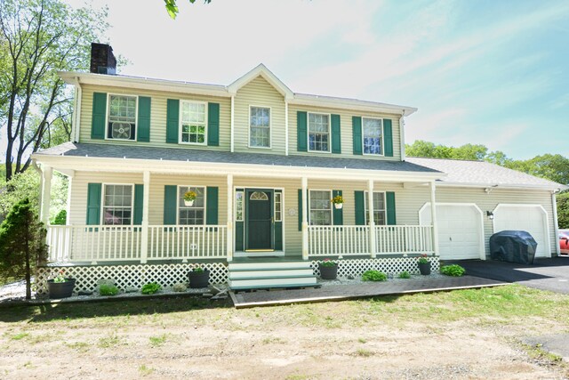 39 Warner St, Bristol, CT 06010 - view of front of house featuring covered porch, a chimney, asphalt driveway, and an attached garage