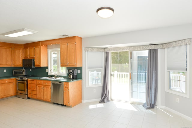 39 Warner St, Bristol, CT 06010 - kitchen with stainless steel appliances, dark countertops, plenty of natural light, and baseboards
