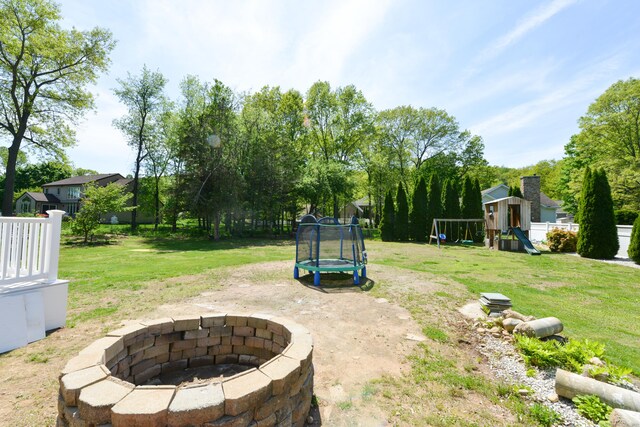 39 Warner St, Bristol, CT 06010 - view of green lawn with a trampoline, a playground, and an outdoor fire pit
