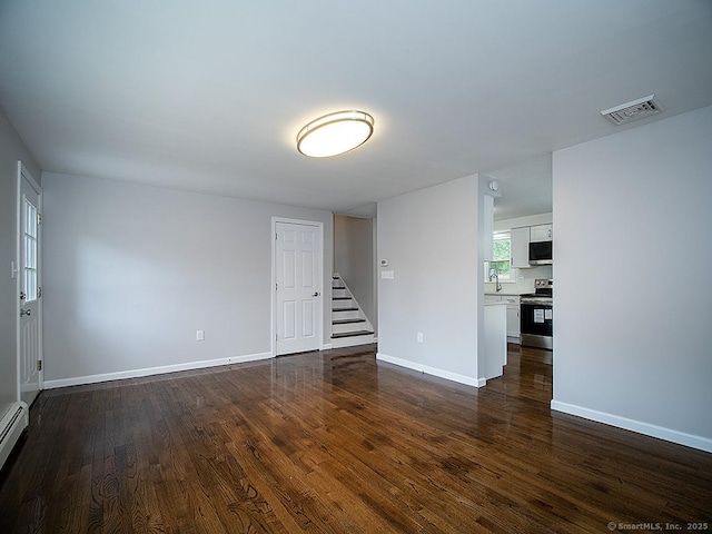 179 Anns Farm Rd, Hamden, CT 06518 - spare room with stairs, dark wood-type flooring, baseboards, and a baseboard heating unit