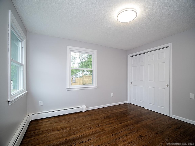 179 Anns Farm Rd, Hamden, CT 06518 - unfurnished bedroom featuring a baseboard heating unit, dark wood-style floors, a closet, baseboards, and a textured ceiling