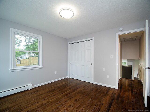 179 Anns Farm Rd, Hamden, CT 06518 - unfurnished bedroom with dark wood-type flooring, a baseboard heating unit, a closet, baseboards, and a textured ceiling
