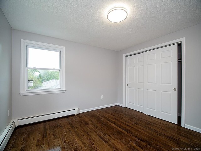 179 Anns Farm Rd, Hamden, CT 06518 - unfurnished bedroom with dark wood-style flooring, a closet, baseboard heating, and baseboards