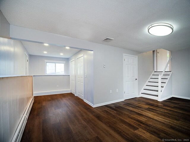 179 Anns Farm Rd, Hamden, CT 06518 - basement with wood finished floors, a baseboard heating unit, baseboards, and a textured ceiling