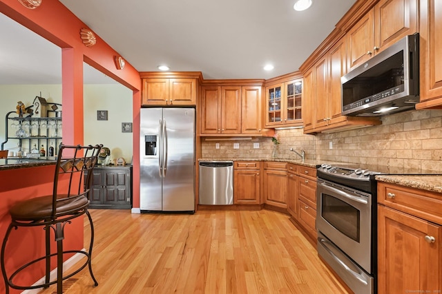 156 Governor Trumbull Way Unit 156, Trumbull, CT 06611 - kitchen featuring stainless steel appliances, light stone counters, light wood-type flooring, brown cabinets, and recessed lighting