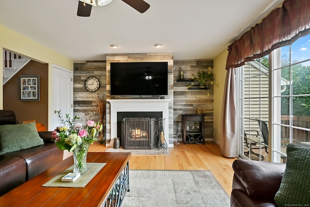156 Governor Trumbull Way Unit 156, Trumbull, CT 06611 - living room featuring a fireplace, ceiling fan, wooden walls, wood finished floors, and an accent wall