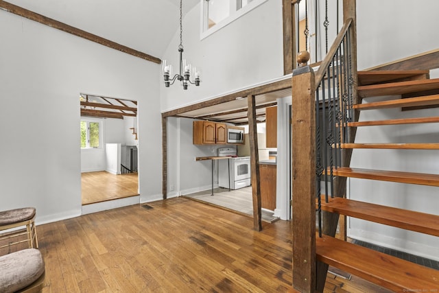 231 Broad St, Norwich, CT 06360 - stairs with wood-type flooring, high vaulted ceiling, a chandelier, and baseboards