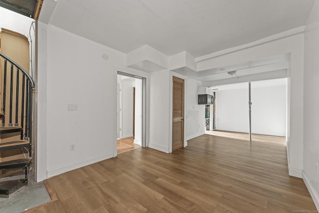 231 Broad St, Norwich, CT 06360 - unfurnished living room with wood finished floors, stairway, and baseboards