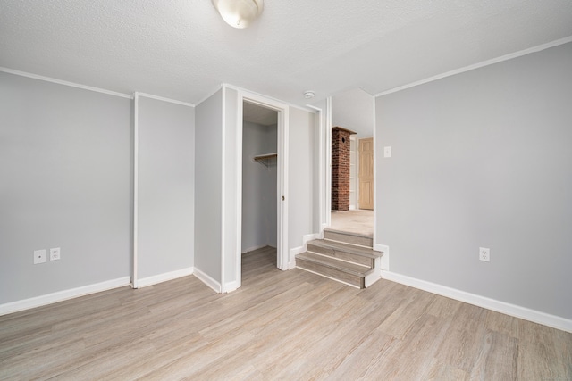 74 Mill St, Middletown, CT 06457 - unfurnished bedroom with light wood-style floors, baseboards, ornamental molding, a closet, and a textured ceiling