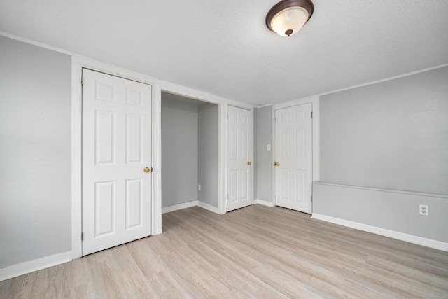 74 Mill St, Middletown, CT 06457 - unfurnished bedroom featuring light wood-type flooring, baseboards, and a textured ceiling