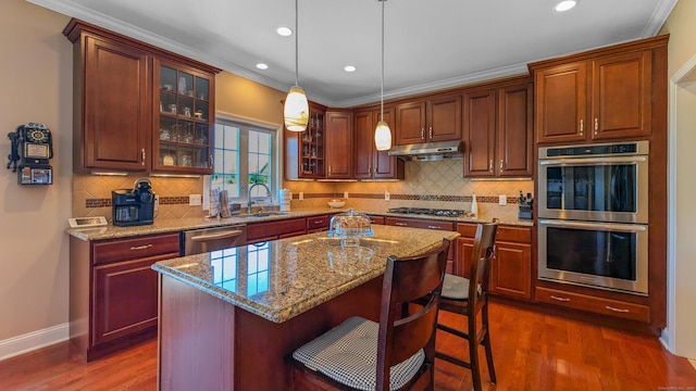753 N Farms Rd, Wallingford, CT 06492 - kitchen featuring appliances with stainless steel finishes, under cabinet range hood, a sink, dark wood finished floors, and glass insert cabinets