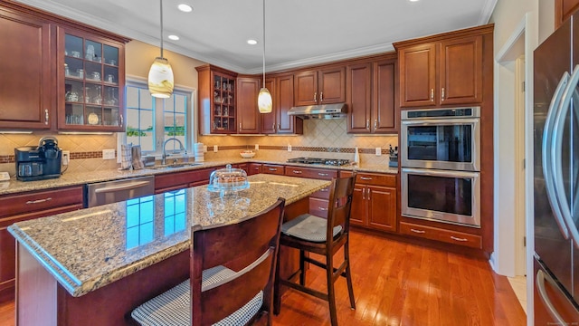 753 N Farms Rd, Wallingford, CT 06492 - kitchen with stainless steel appliances, a sink, wood finished floors, recessed lighting, and a kitchen bar