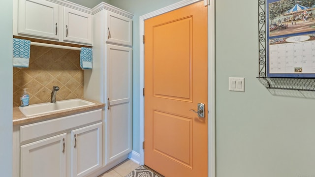 753 N Farms Rd, Wallingford, CT 06492 - kitchen featuring a sink, white cabinets, tasteful backsplash, light tile patterned floors, and light countertops