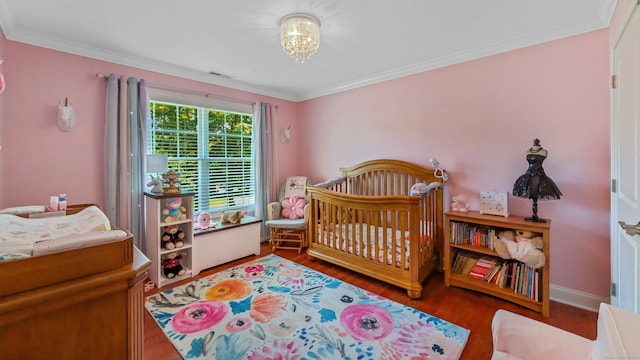 753 N Farms Rd, Wallingford, CT 06492 - bedroom with wood finished floors, ornamental molding, baseboards, and a crib