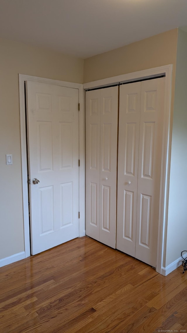 70 Lantern Park Dr Unit 1, Naugatuck, CT 06770 - unfurnished bedroom featuring a closet, wood finished floors, and baseboards