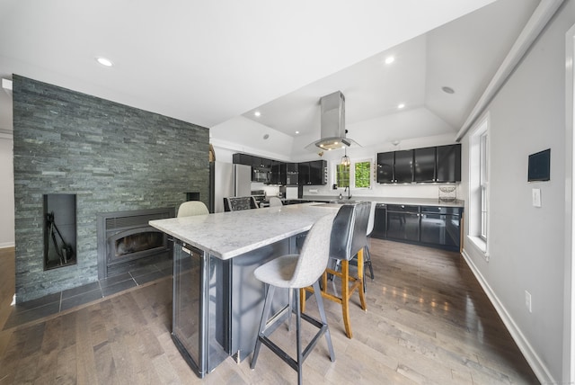 108 Hamburg Rd, Lyme, CT 06371 - kitchen with freestanding refrigerator, a kitchen bar, dark cabinets, a center island, and a tile fireplace