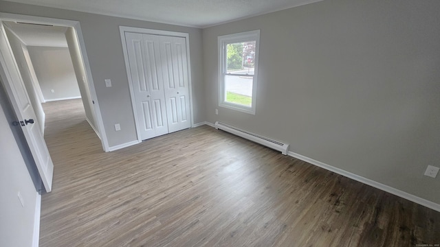 3 Norwood Ave, New London, CT 06320 - unfurnished bedroom with a baseboard heating unit, wood finished floors, baseboards, and a closet