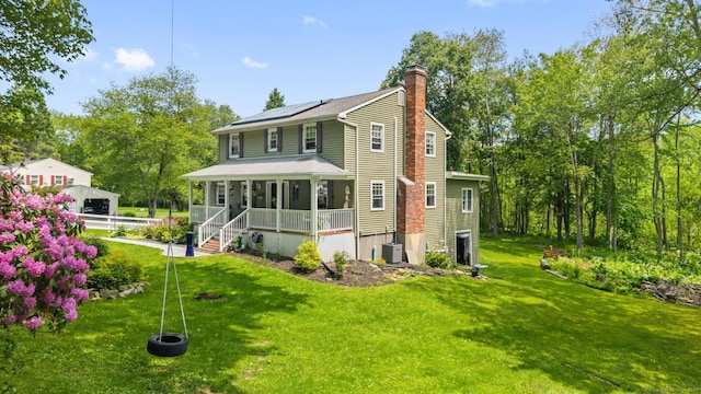 33 Crestview Dr, Brookfield, CT 06804 - back of property with a porch, a chimney, solar panels, and a lawn