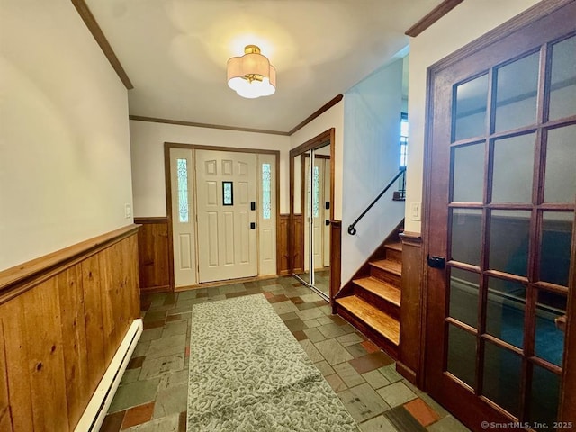 687 Sprout Brook Rd, Putnam Valley, NY 10579 - foyer with a baseboard heating unit, a wainscoted wall, crown molding, stairway, and stone tile floors