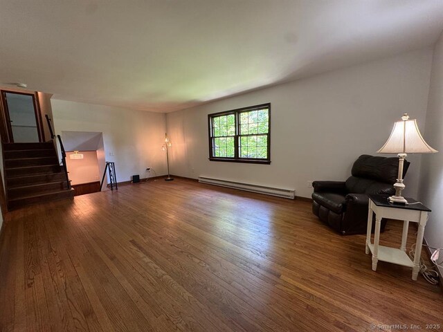 687 Sprout Brook Rd, Putnam Valley, NY 10579 - living area featuring a baseboard heating unit, dark wood-style floors, stairway, and baseboards