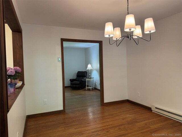 687 Sprout Brook Rd, Putnam Valley, NY 10579 - spare room with a baseboard heating unit, wood finished floors, a chandelier, and baseboards