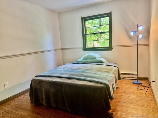 687 Sprout Brook Rd, Putnam Valley, NY 10579 - bedroom featuring baseboard heating, wood finished floors, and baseboards