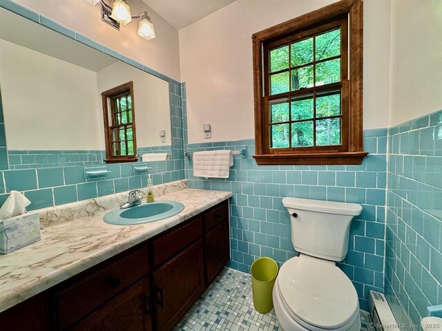 687 Sprout Brook Rd, Putnam Valley, NY 10579 - half bathroom featuring vanity, healthy amount of natural light, tile patterned flooring, a wainscoted wall, and tile walls