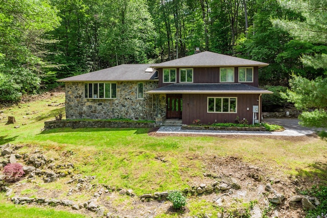 14 Old Bridge Rd W, New Fairfield, CT 06812 - view of front of property with a front yard, roof with shingles, a chimney, a view of trees, and stone siding